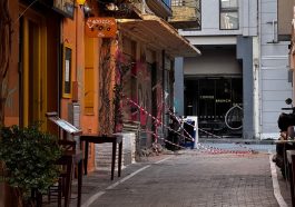 Explore a quaint alleyway in Athens, Greece, featuring inviting cafés and warm colors on a sunny day.